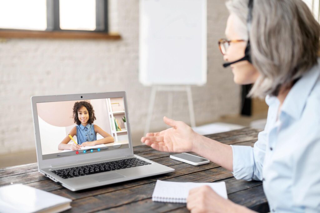 Online tutor teaching students through a live video class